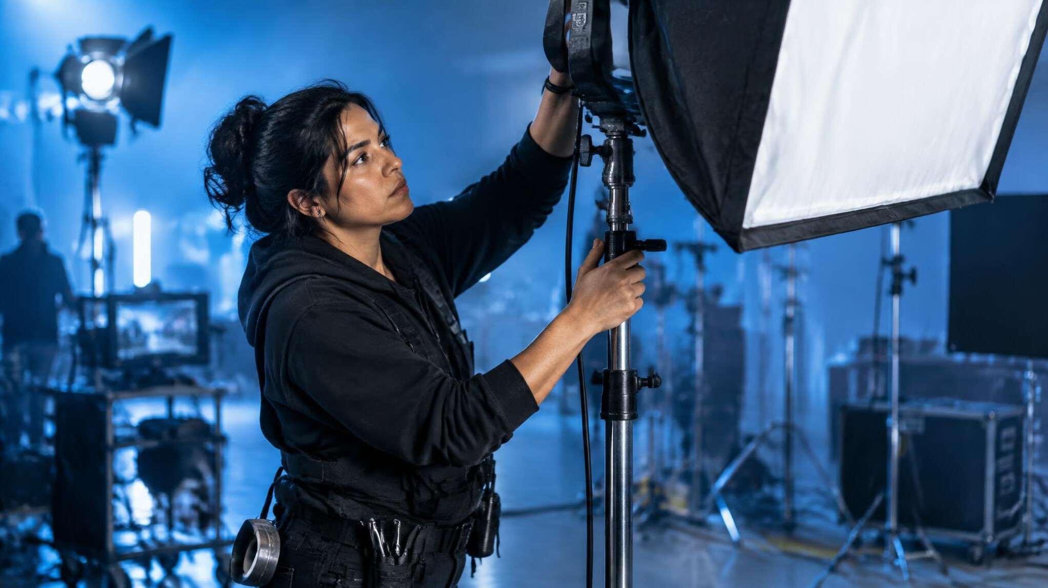 Crew member positioning a softbox light on set
